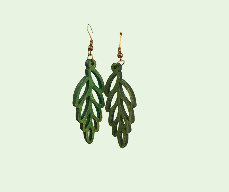 Green leaf-shaped earrings on a light green background