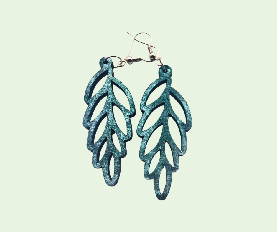 Teal leaf-shaped earrings on a light green background