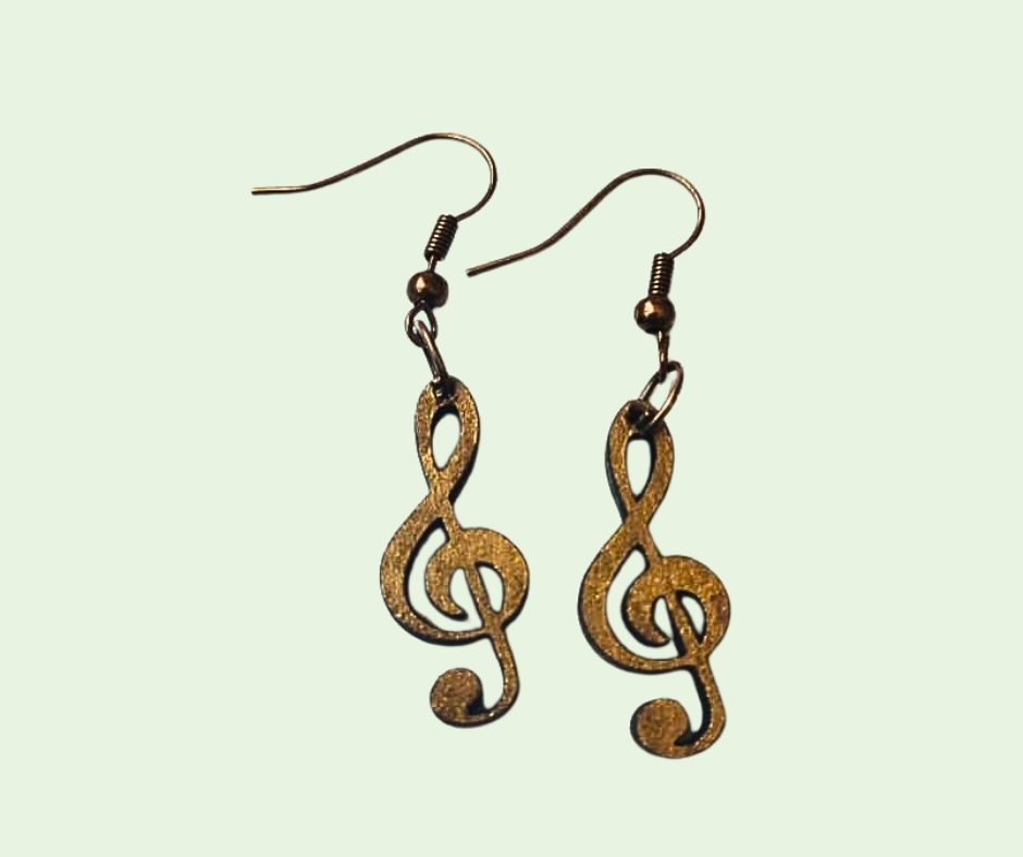 Bronze treble clef earrings on a light green background
