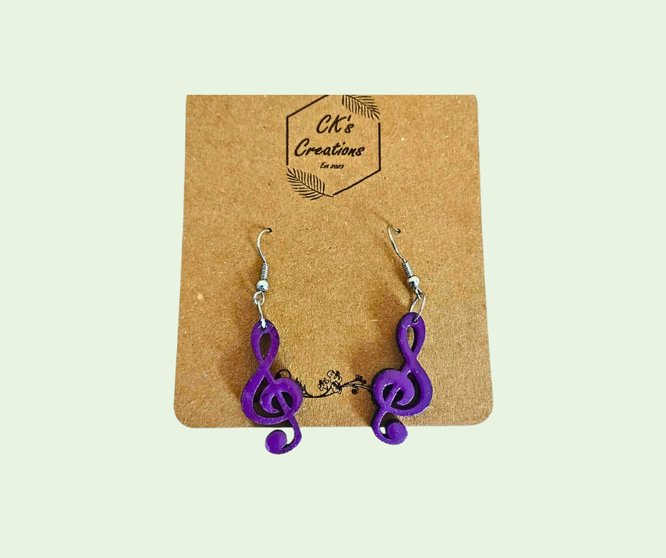 Purple treble clef earrings on a 'CK's Creations' branded card against a light beige background