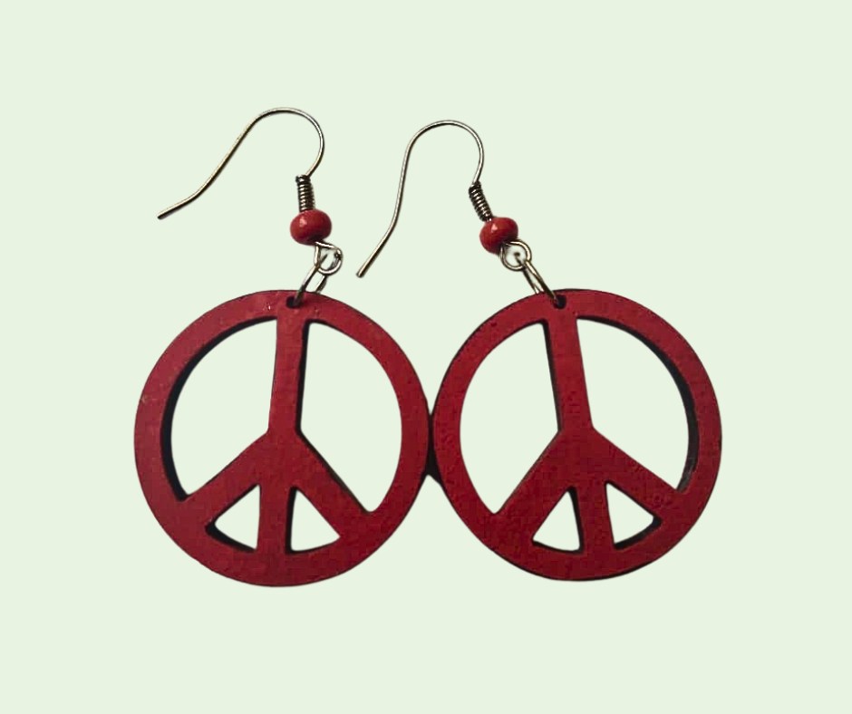 Red peace symbol earrings on a light green background