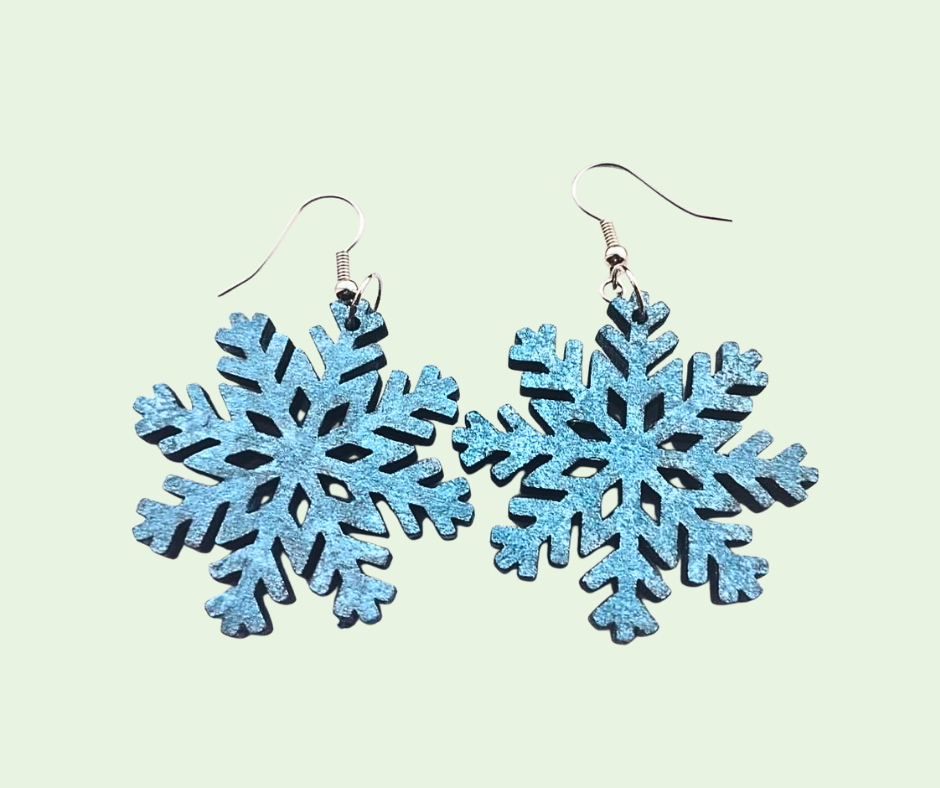Blue snowflake earrings on a light green background
