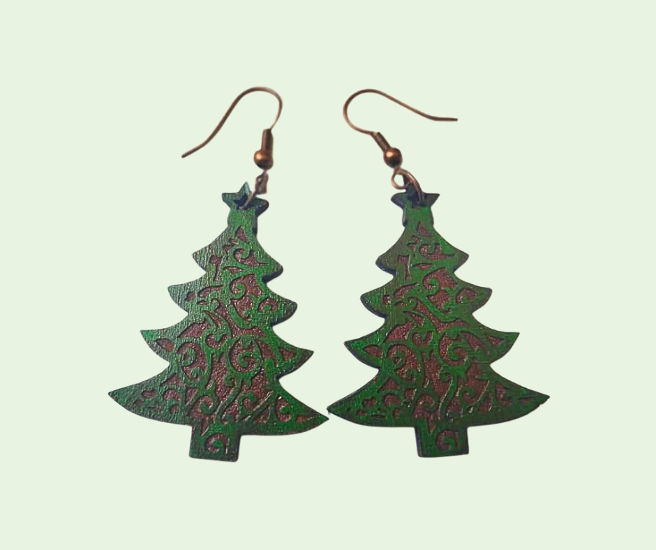 Green tree-shaped earrings on a light green background